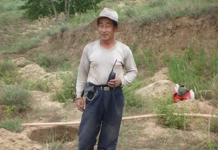 工具を持ってこちらを向いている男性